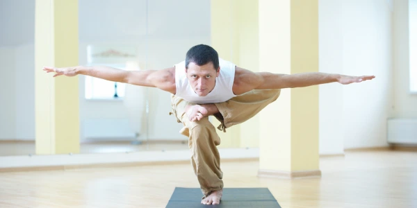 A man practicing yoga in a bright room, symbolizing inner strength and self-discovery for all ages